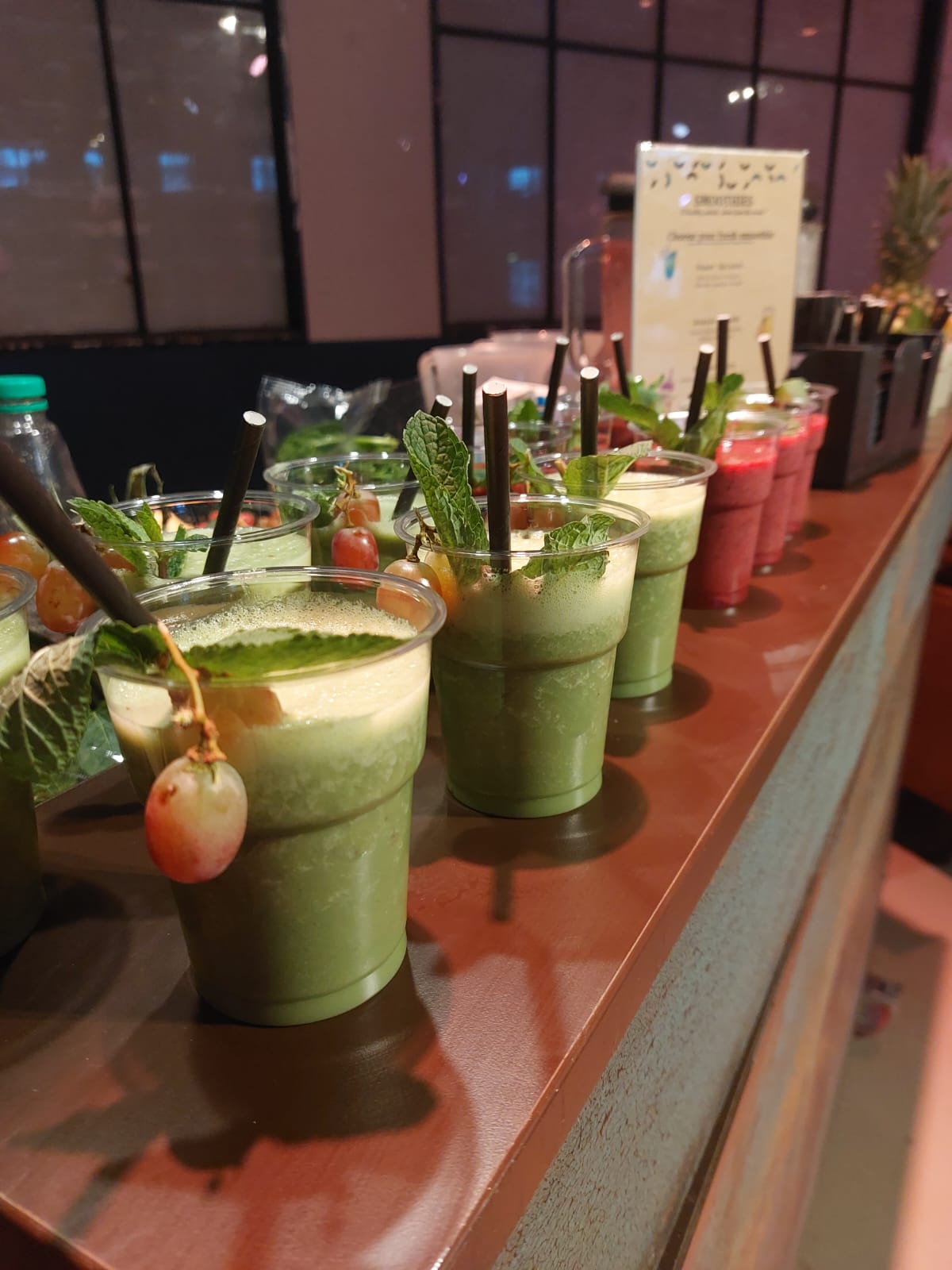 Rij verse shakes op een bar, afgemaakt met muntblaadjes en vers fruit.