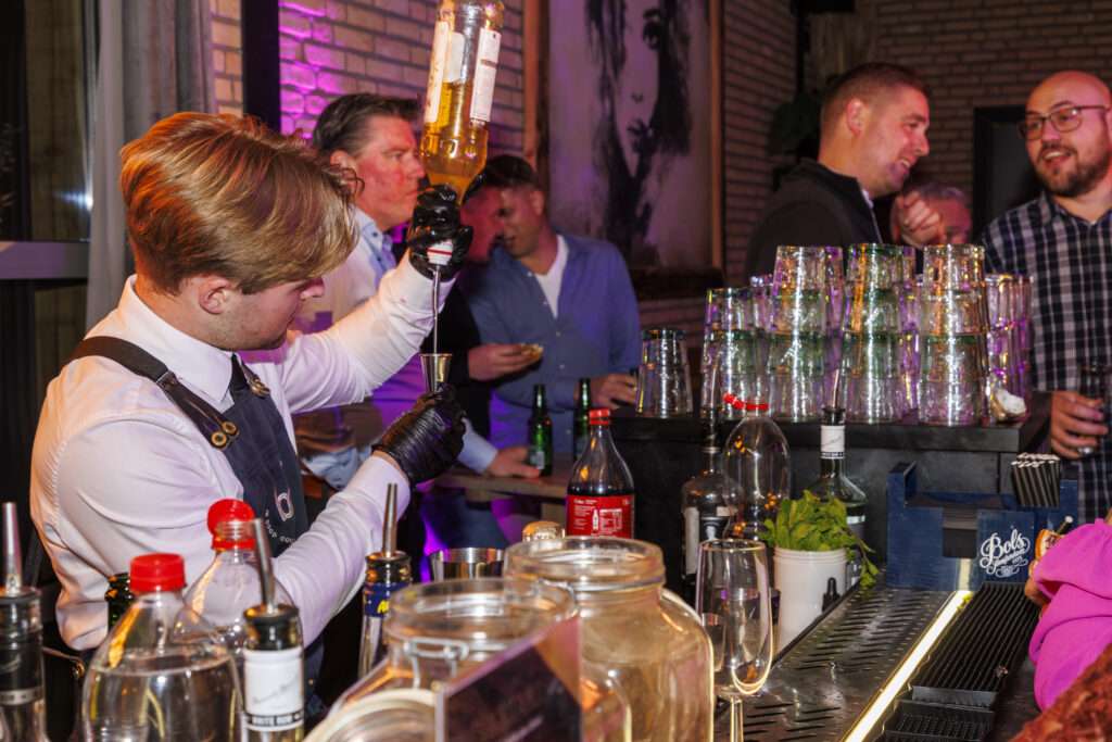 bartender achter cocktailbar op bedrijfsfeest