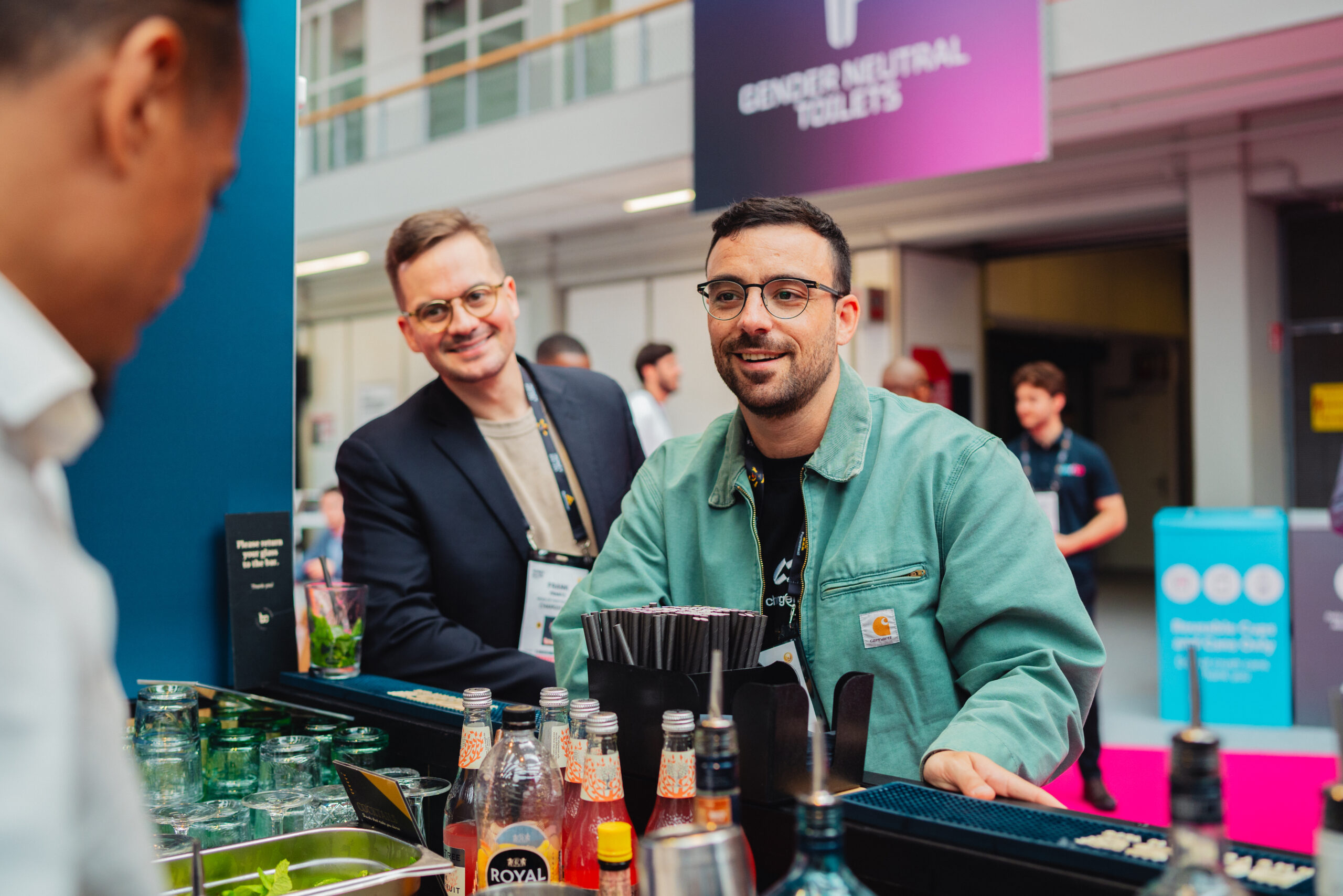 Bartender in gesprek met bezoekers aan de mobiele cocktailbar op een congres