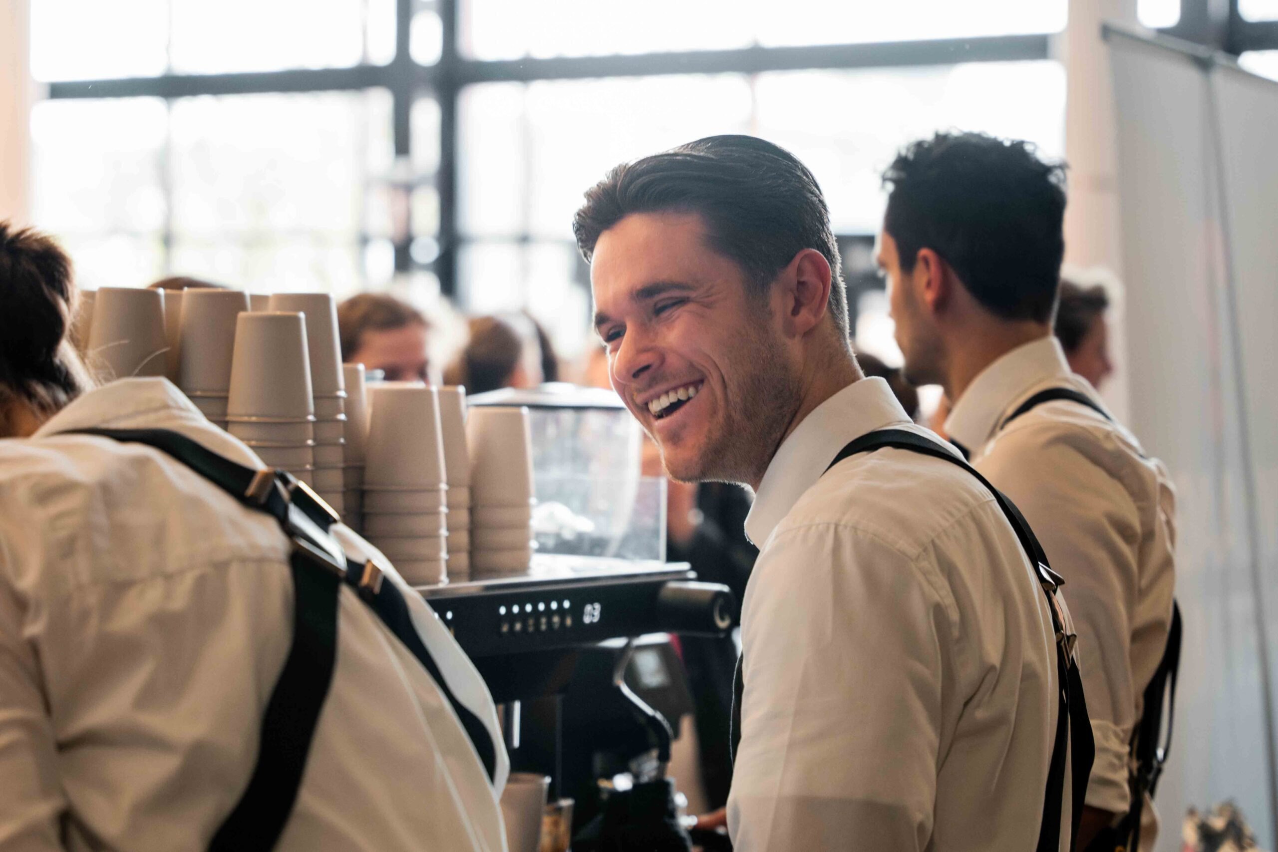 Barista van Bar Company lacht achter de koffiebar op een beurs