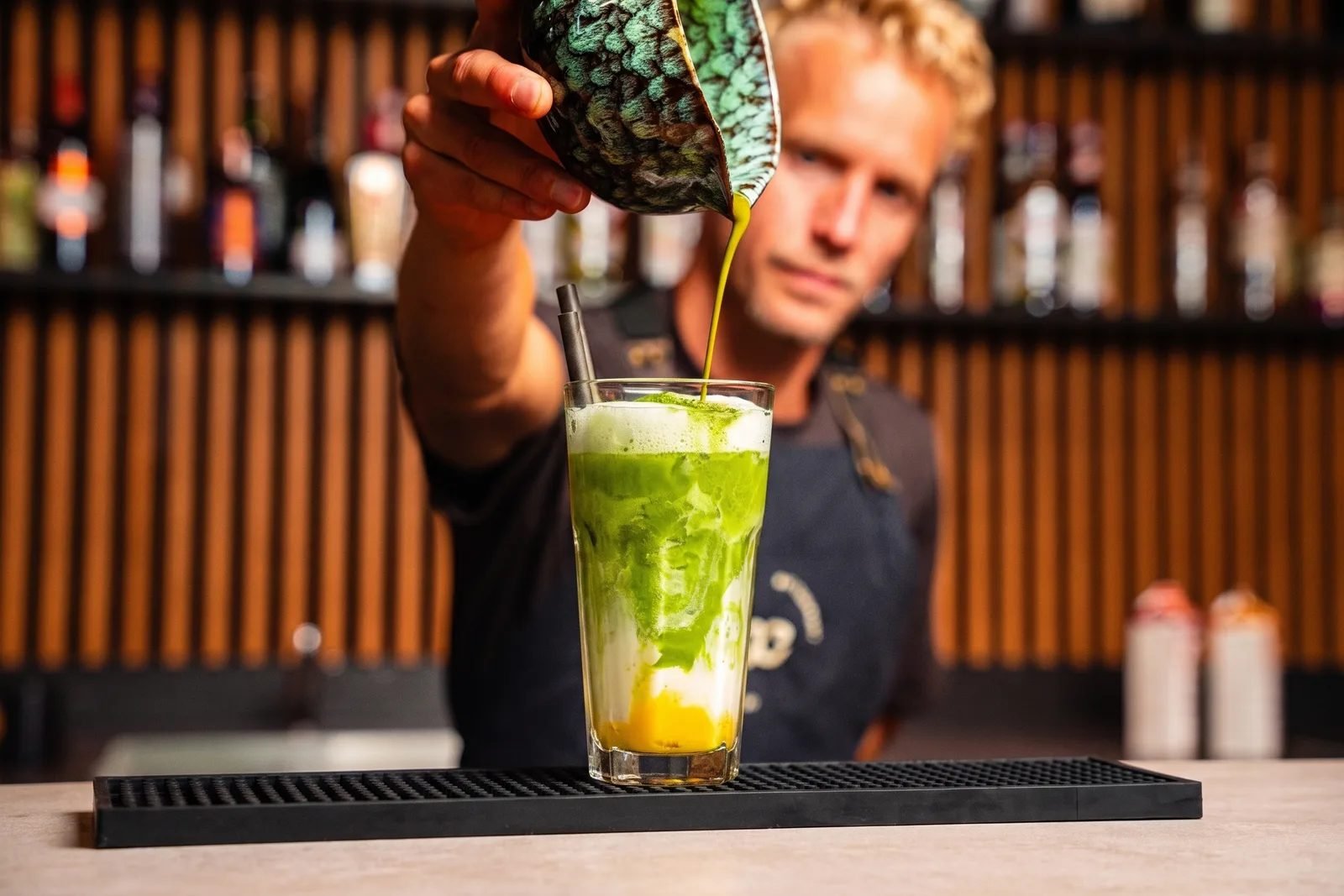 Barista van Bar Company schenkt een iced matcha latte aan de bar